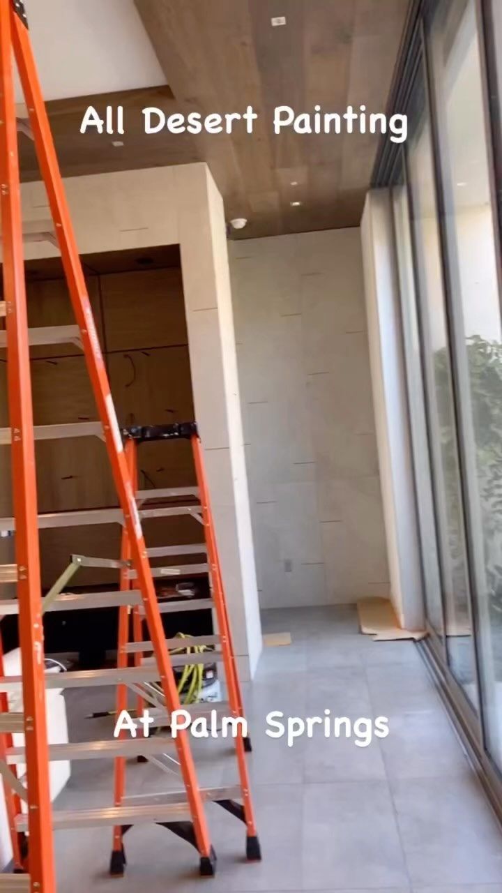 Partially painted balcony with ladder and sliding glass doors at Palm Springs
