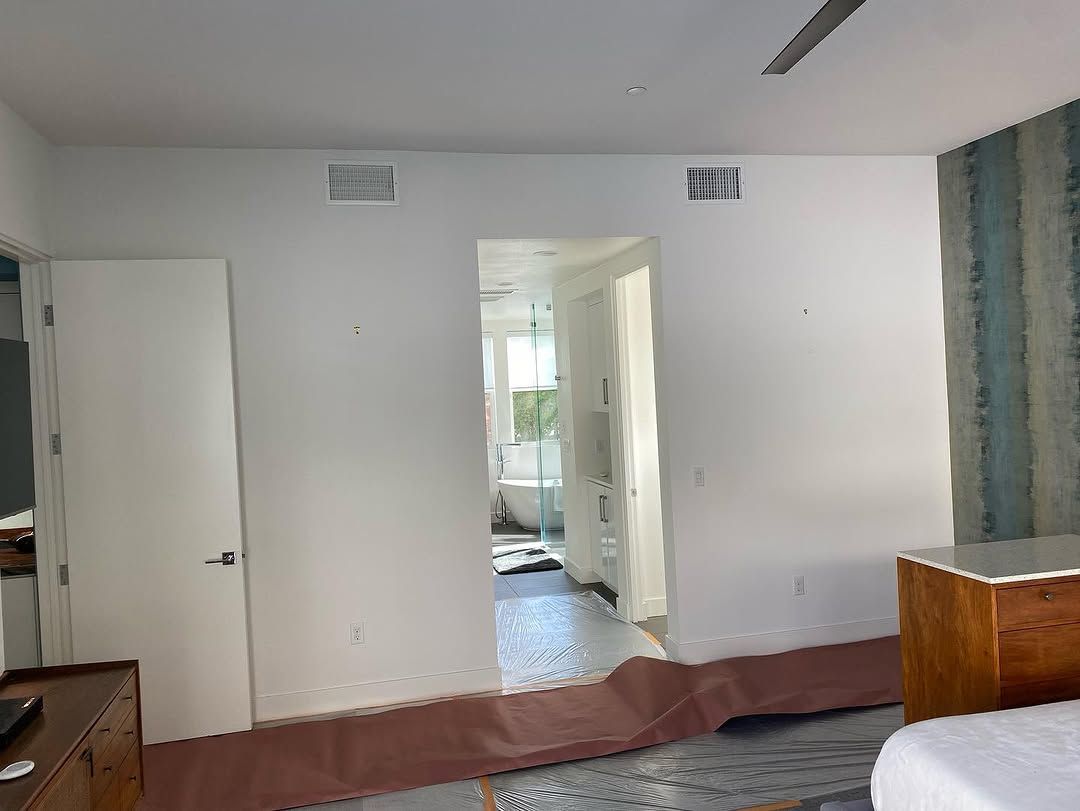 Empty room with white walls, open doorway, and a partially finished floor.