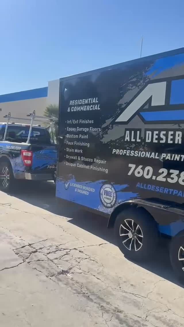 Blue service van with large advertising wrap parked outside a building on a sunny street.