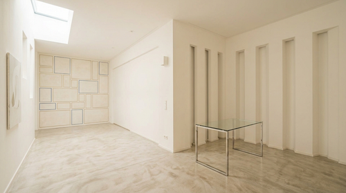 Helles, minimalistisches Interieur in Weiß mit hohen Wandnischen und einem Glastisch vor einer gefliesten Rückwand