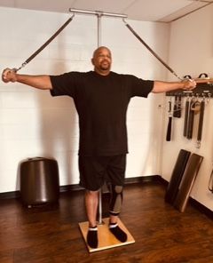 A male performing classical Pilates exercises on a Gratz Ped-o-Pole in a private Pilates session focusing on Posture.

