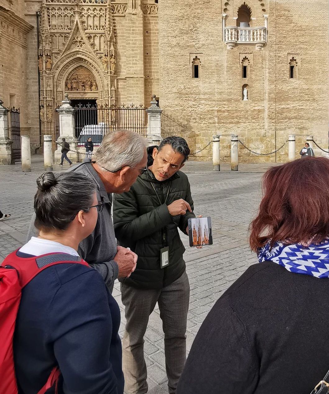 A group of people are standing around talking to each other