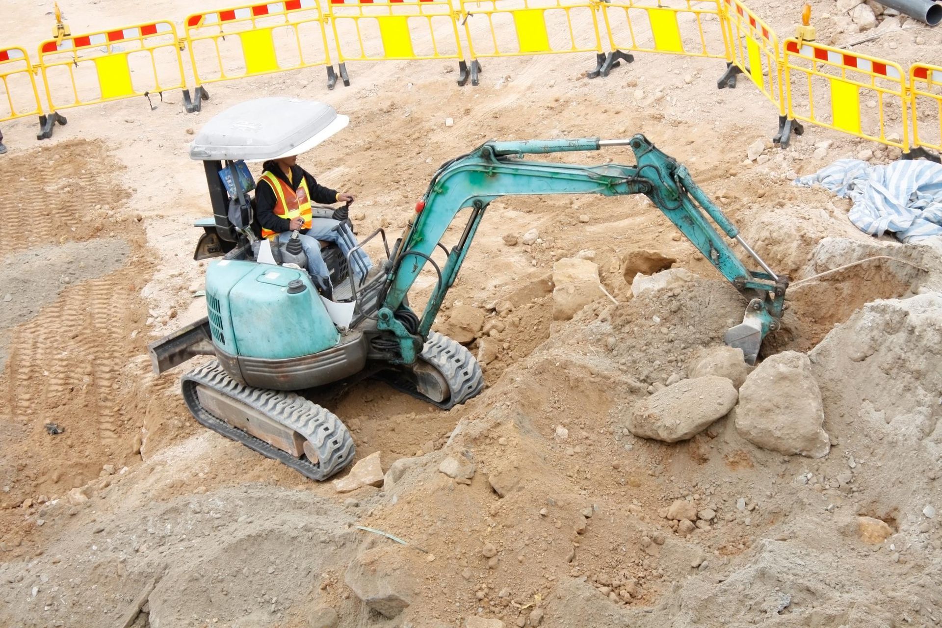 a construction site with a small excavator in the middle of it