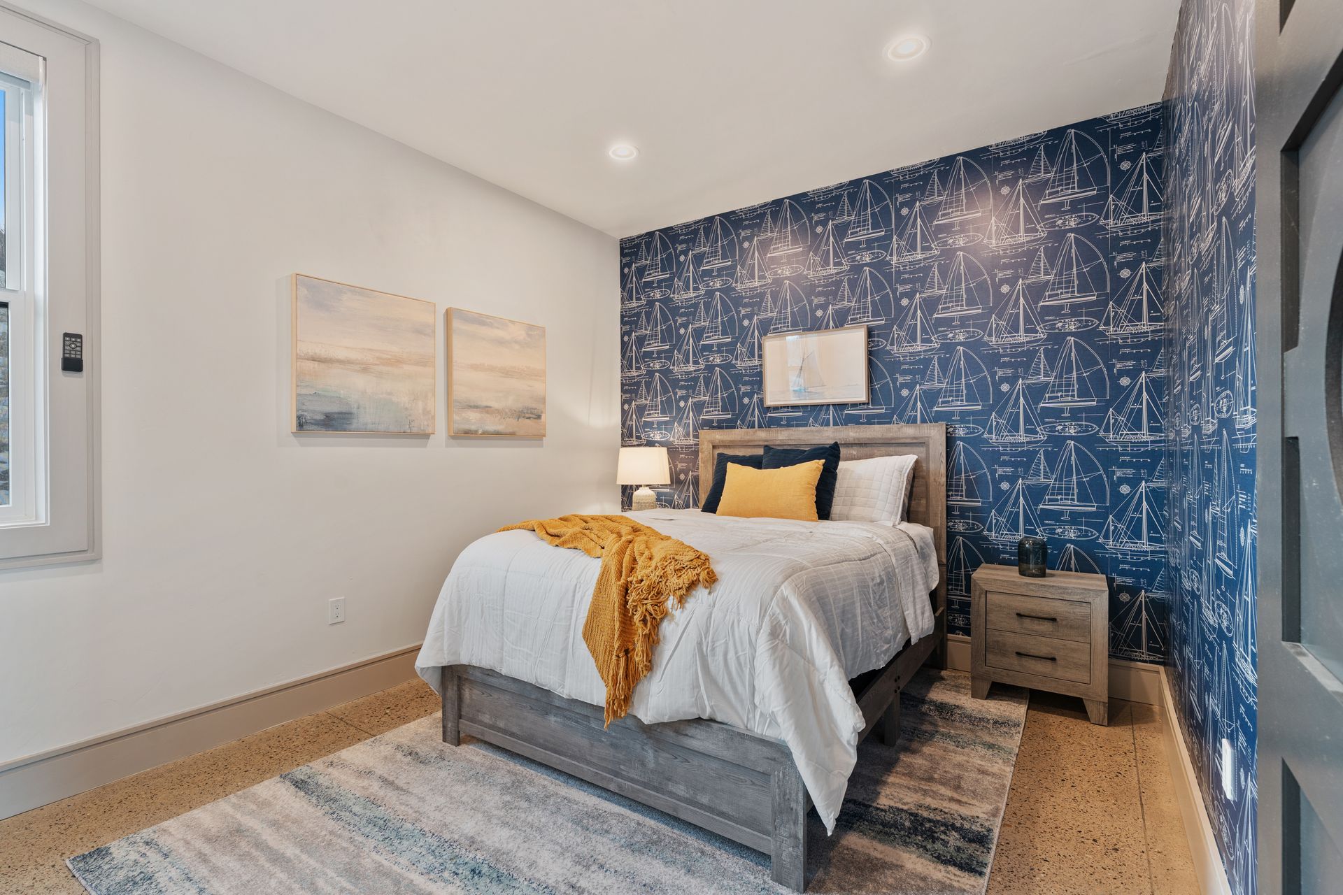Modern bedroom with a bed, blue patterned accent wall, and soft neutral decor