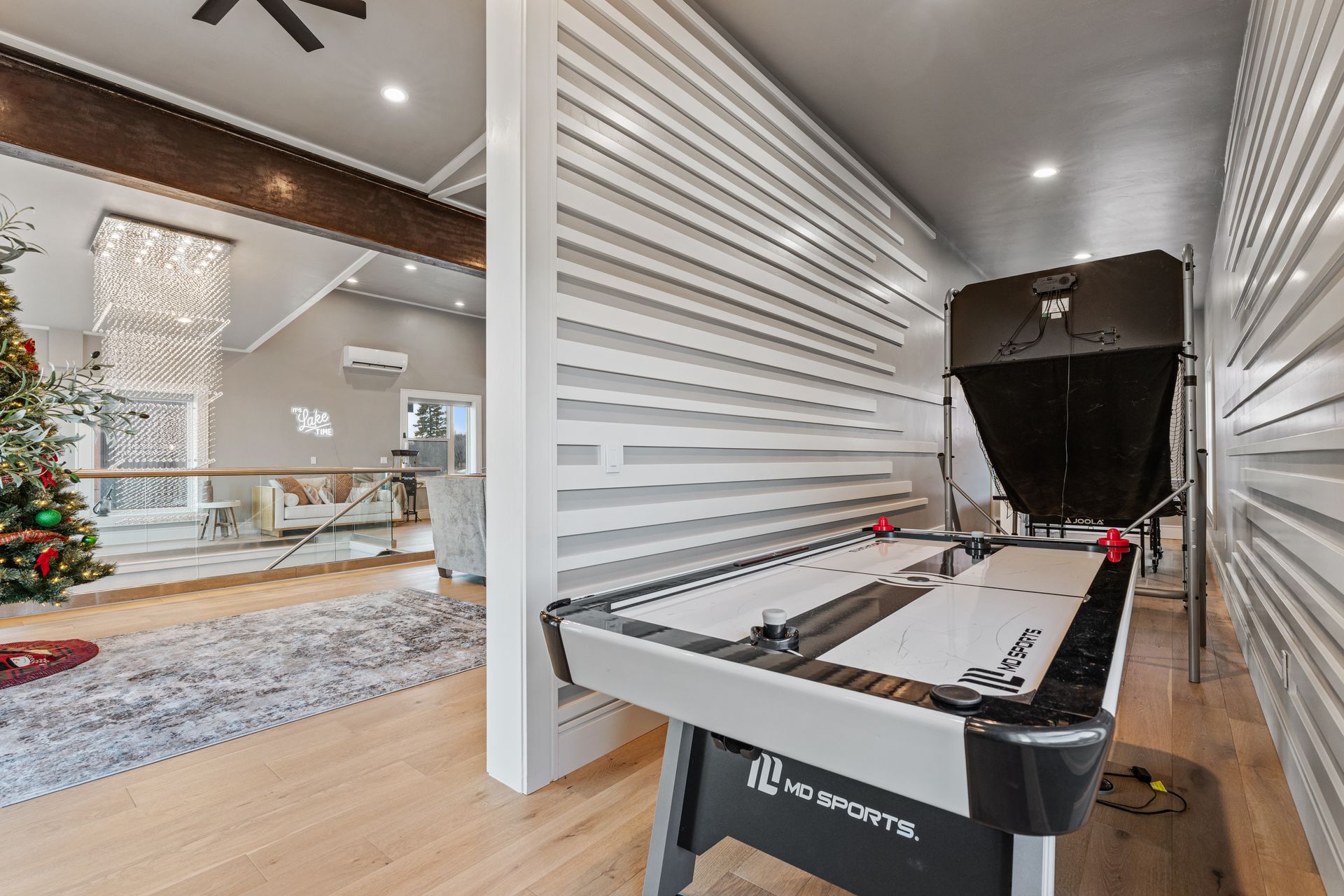 Air hockey table in a modern living room with a fireplace and Christmas tree in the background