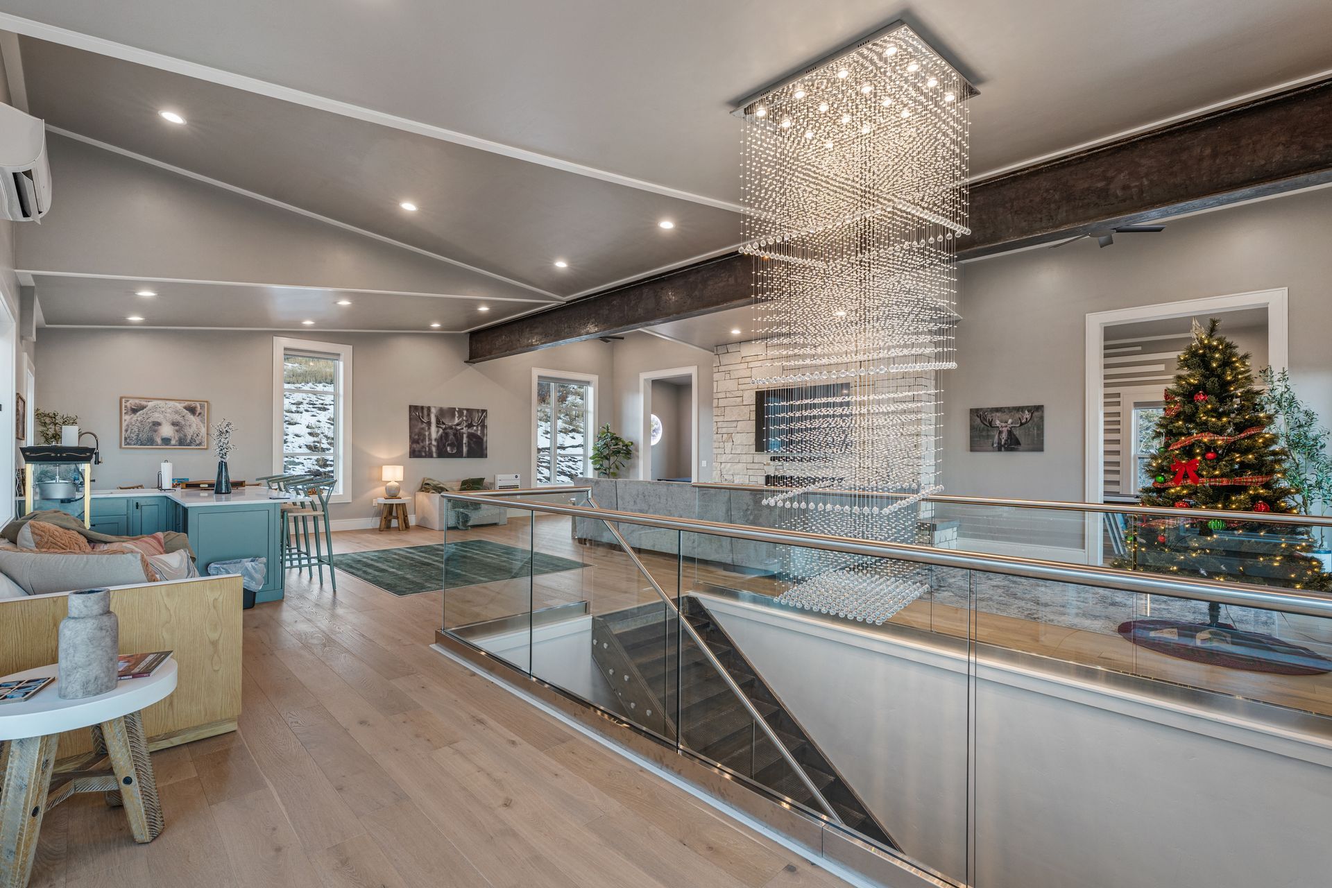 Modern cafe interior with glass railing, hanging chandelier, and decorated Christmas tree