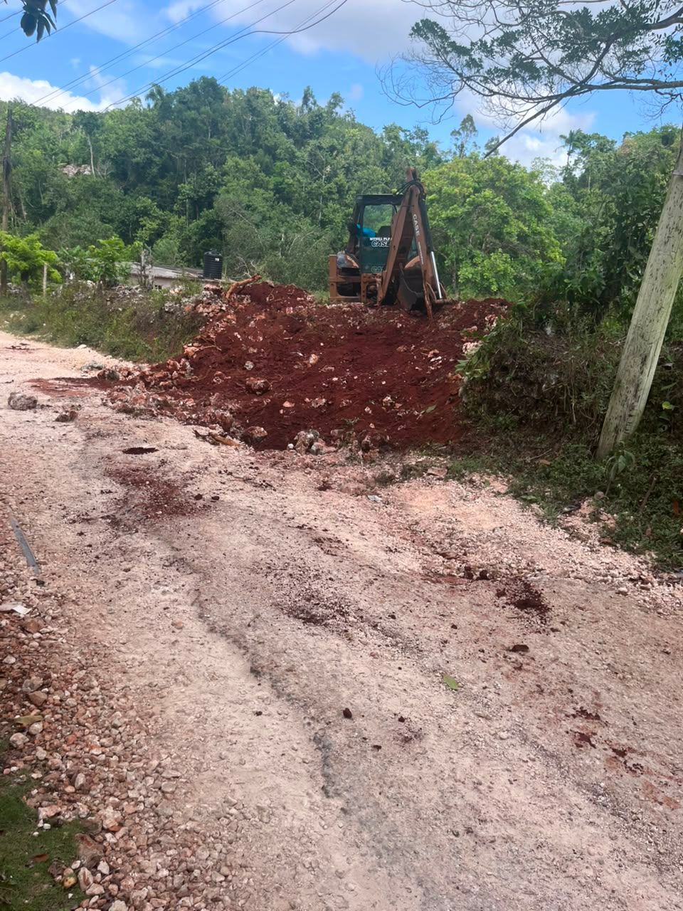 Excavator grading roadside embankment