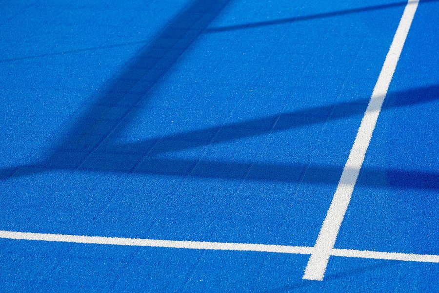 A blue and green tennis court with a net