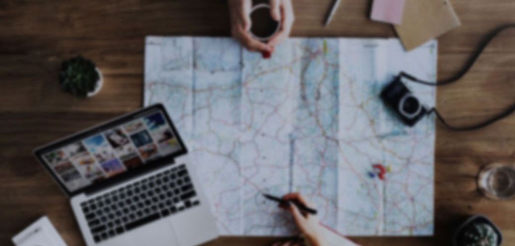 a person is sitting at a table with a map and a laptop . a person is sitting at a table with a map and a laptop.