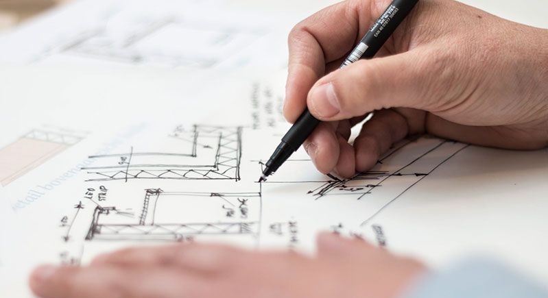 a person is writing on a piece of paper with a pen.