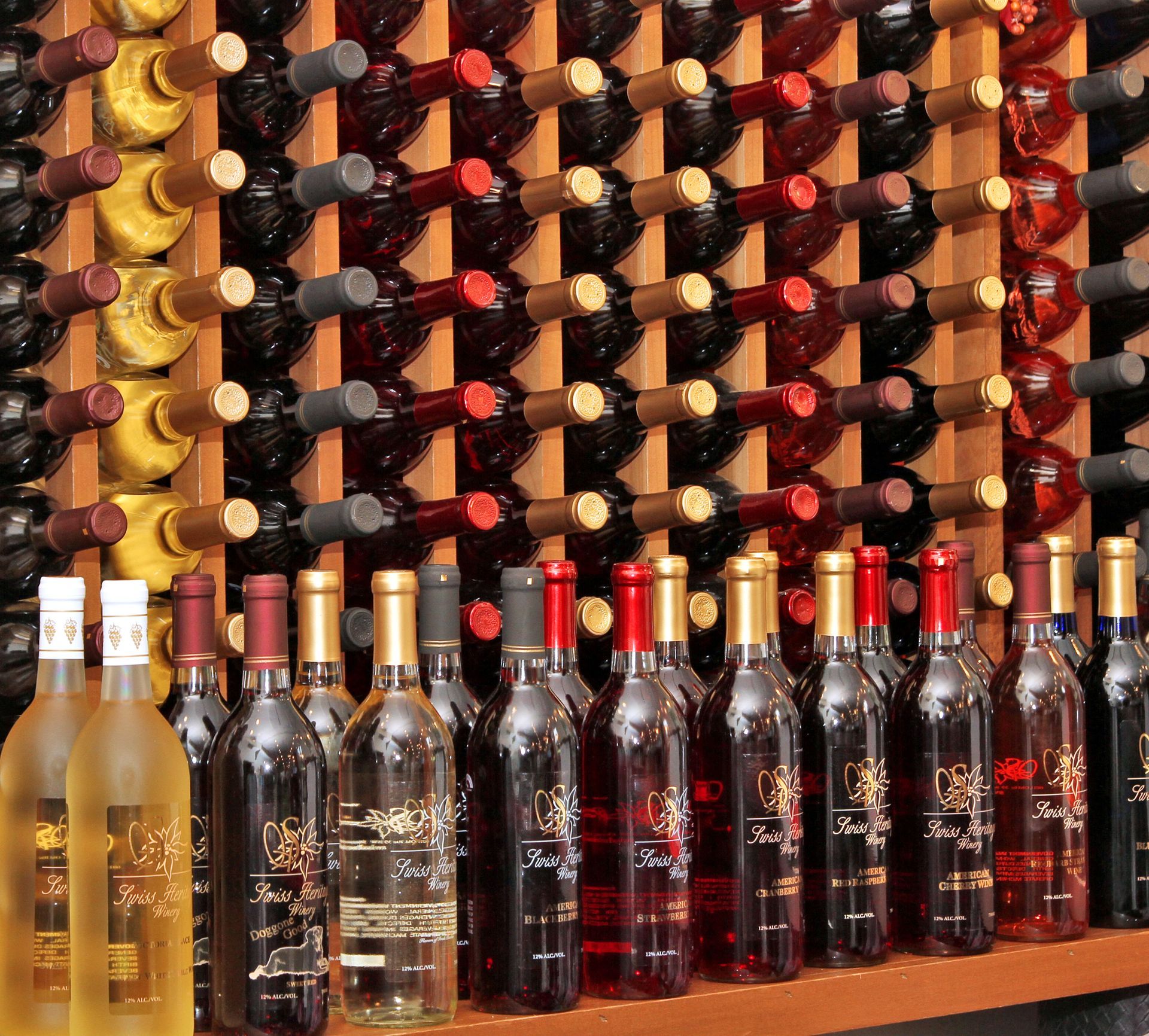Wine bottles on display in a wooden rack with various types of wine visible.