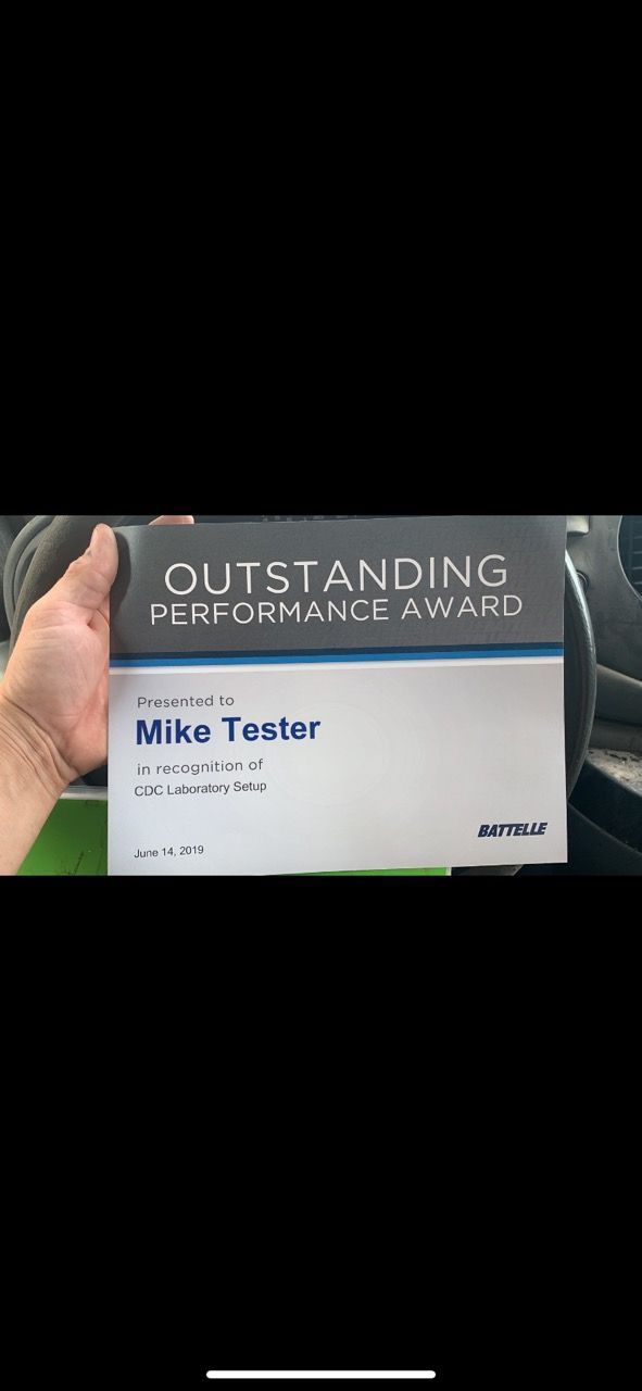 A hand holds a certificate titled 