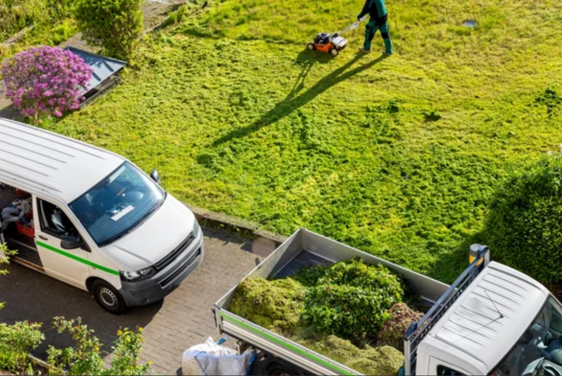 Professional landscaping crew maintaining a lush green lawn with meticulous mowing and garden maintenance services.