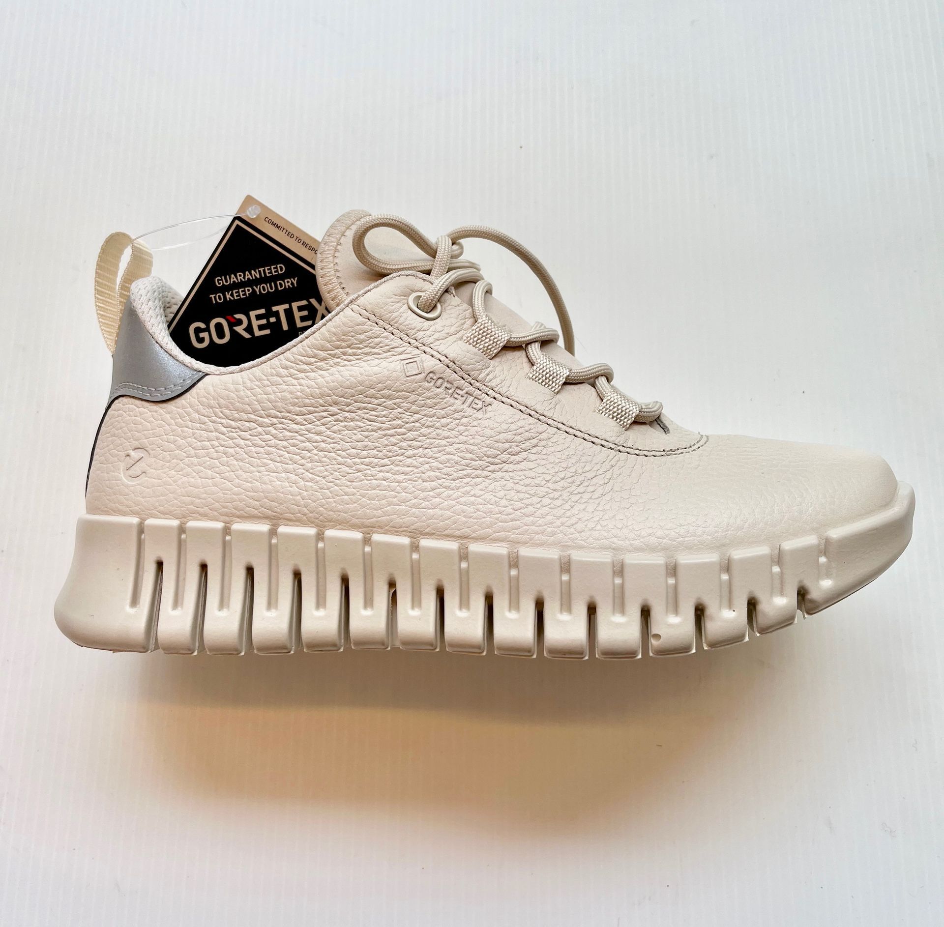 Sneaker color crema con tomaia testurizzata, suola carrarmato ed etichetta GORE-TEX.