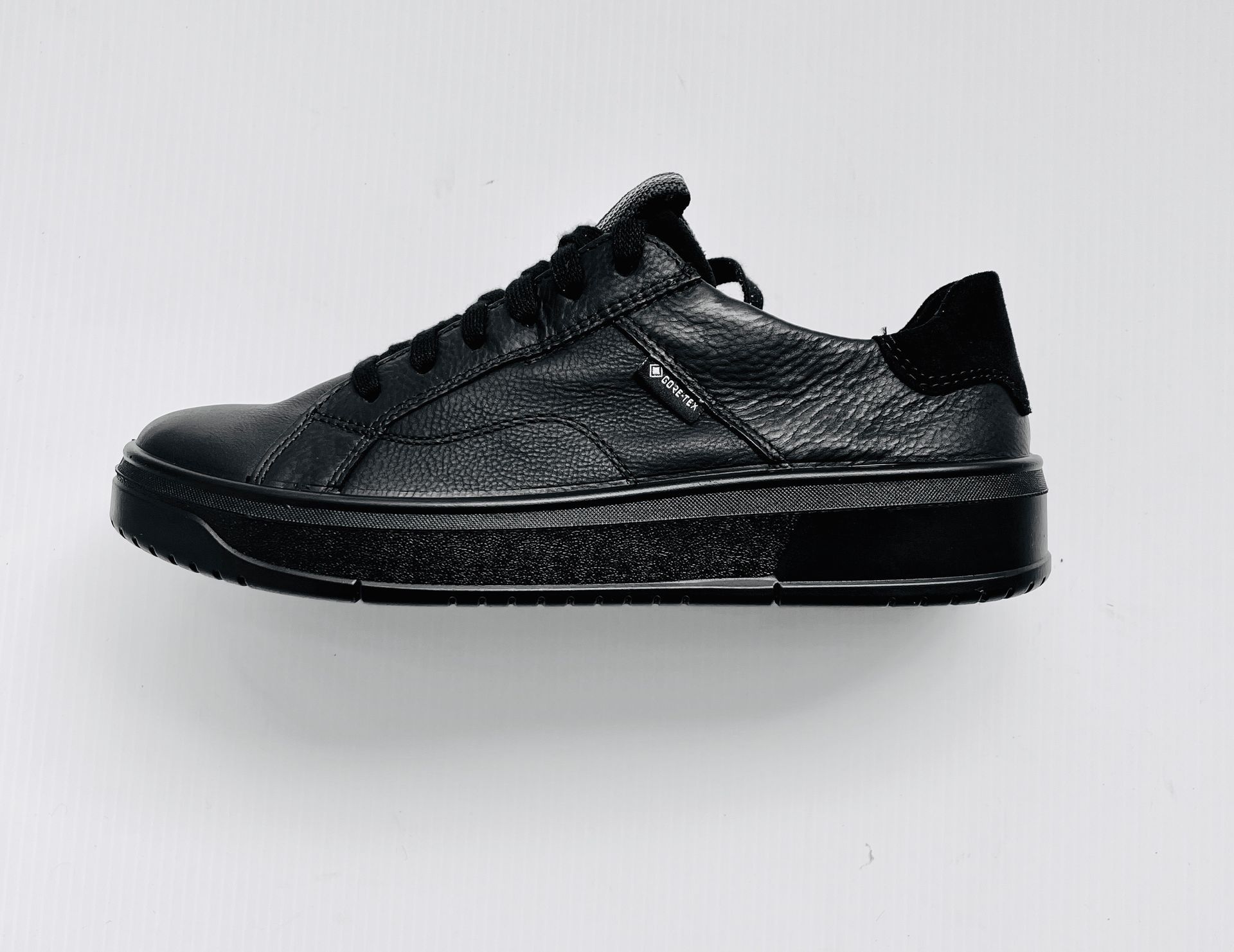 Sneaker in pelle nera con suola con plateau ricoperta di glitter e linguetta sul tallone in pelle scamosciata nera.
