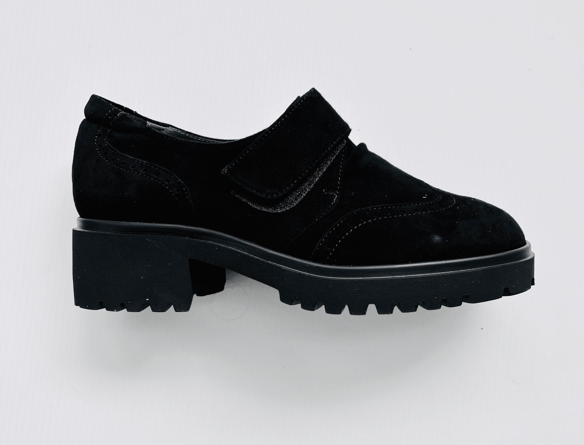 Scarpa in pelle scamosciata nera con cinturino in velcro e suola carrarmato.