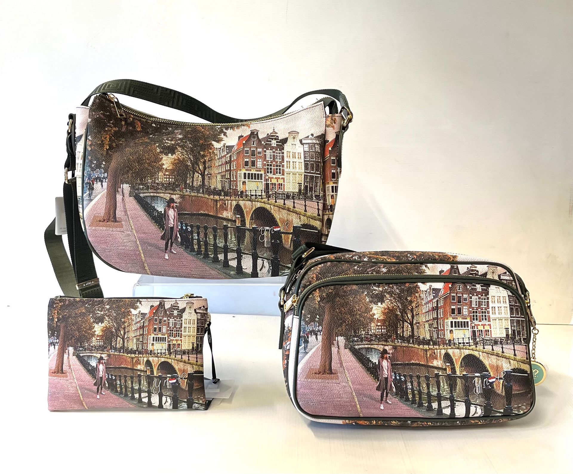 Tre borse abbinate con stampa raffigurante una scena di Amsterdam: una borsa a tracolla, una borsa a tracolla e un portafoglio.