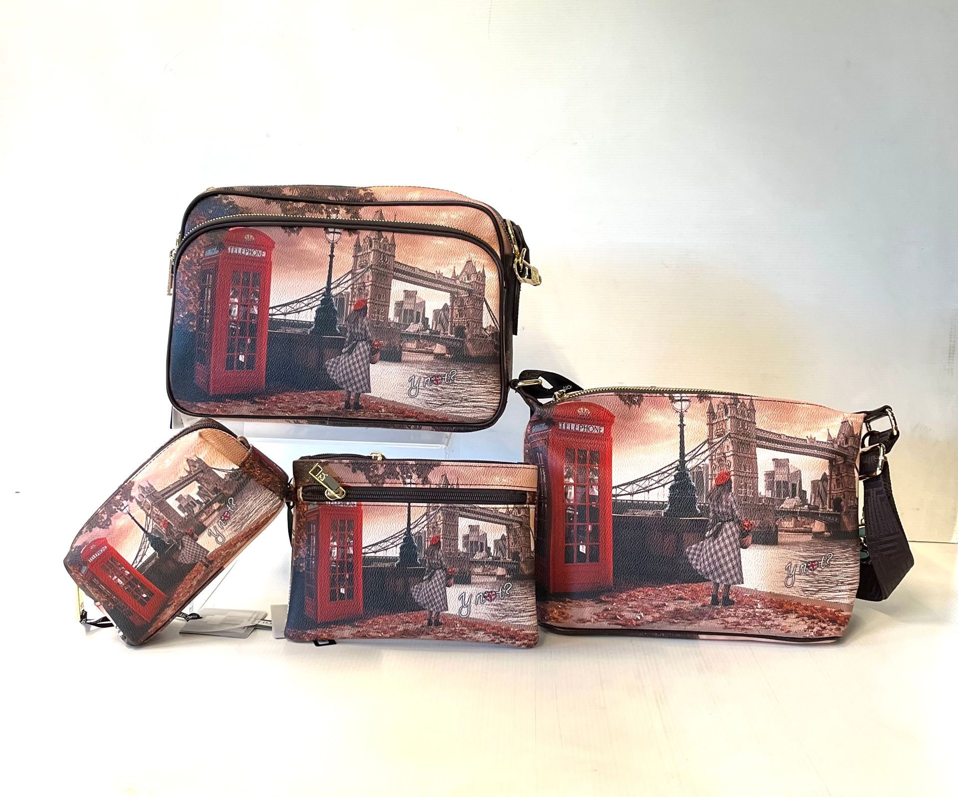 Quattro borse a tema londinese: pochette, pochette con cerniera, tracolla e tote. Decorate con cabine telefoniche rosse e Tower Bridge.