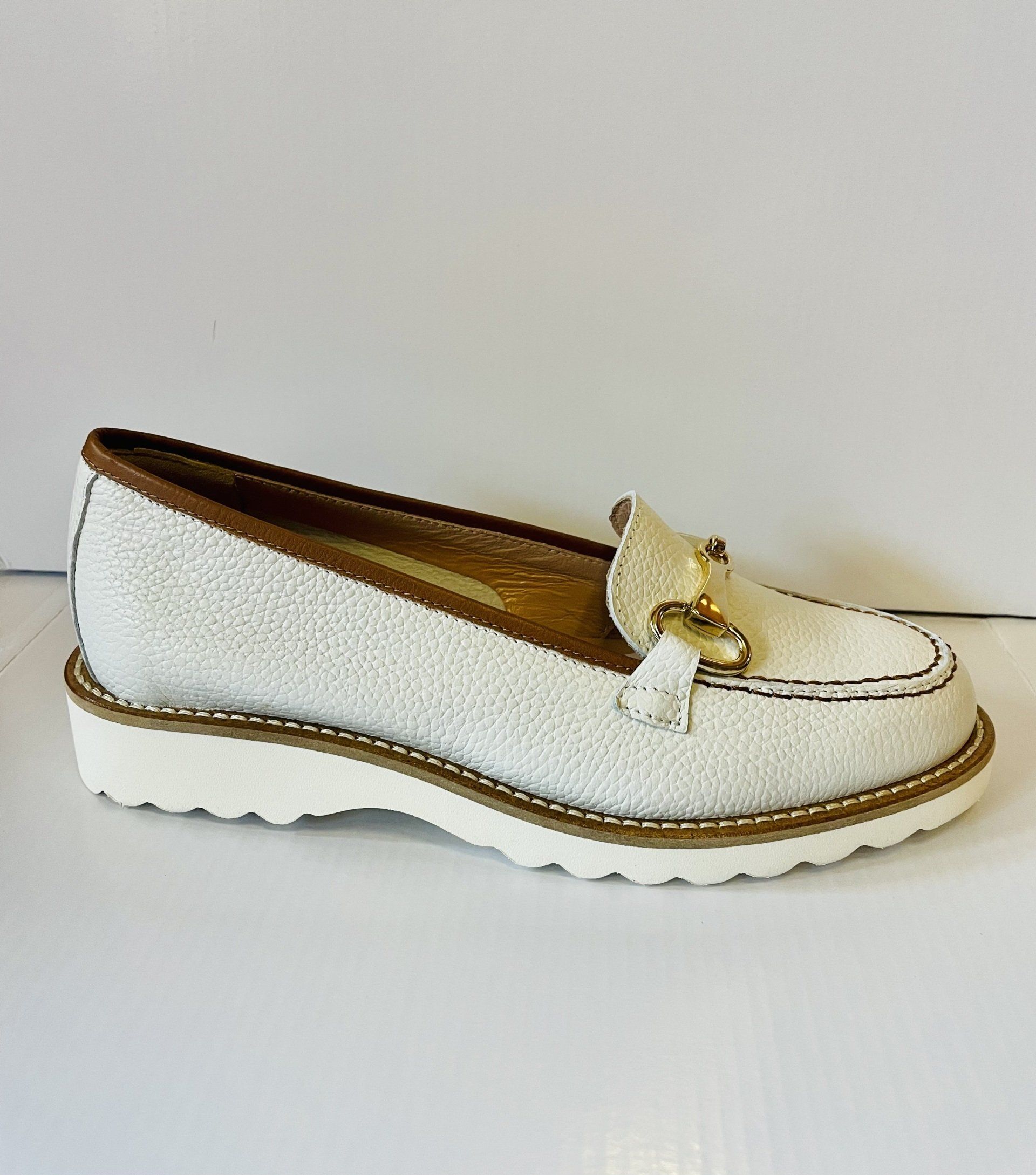 Mocassino bianco e marrone con fibbia e cuciture dorate.