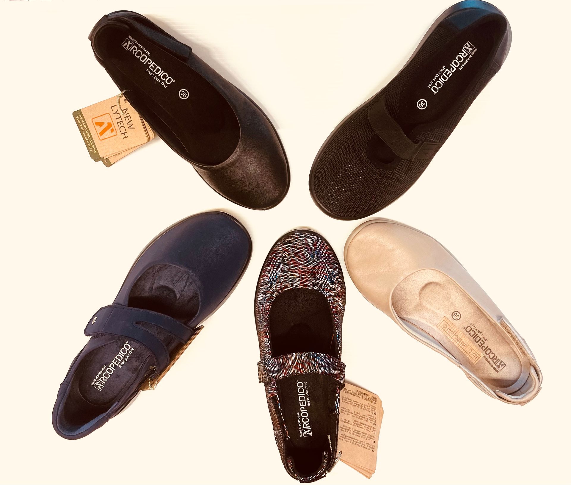 Sei paia di ballerine da donna di vari colori, disposte in cerchio su una superficie color crema, con cartellini dei prezzi.