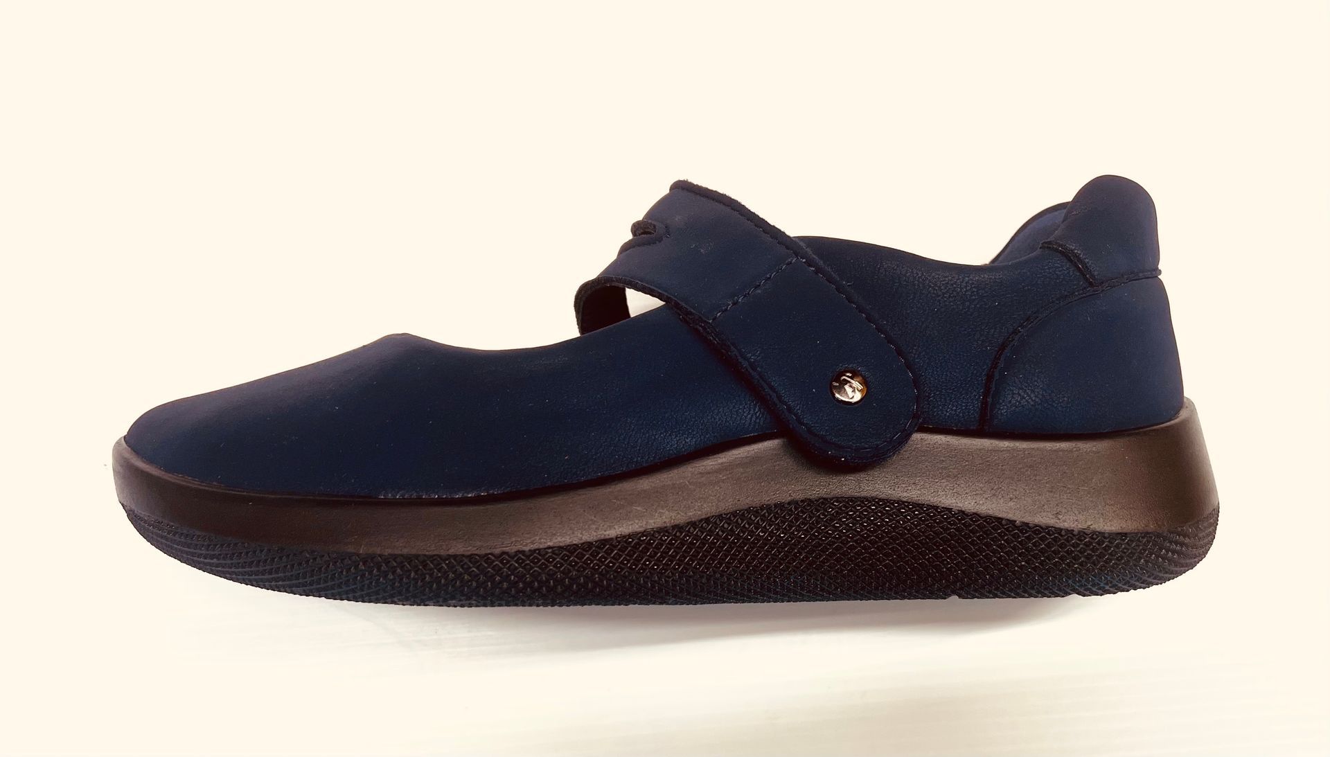 Scarpa Mary Jane blu con suola marrone scuro e cinturino con una piccola gemma.