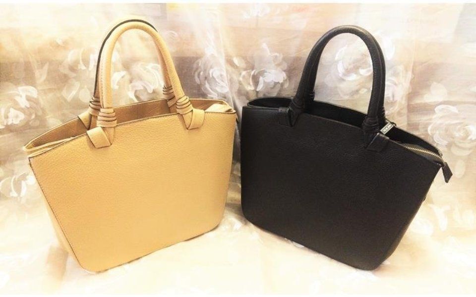 Due borse tote: una beige e una nera, con manici superiori.