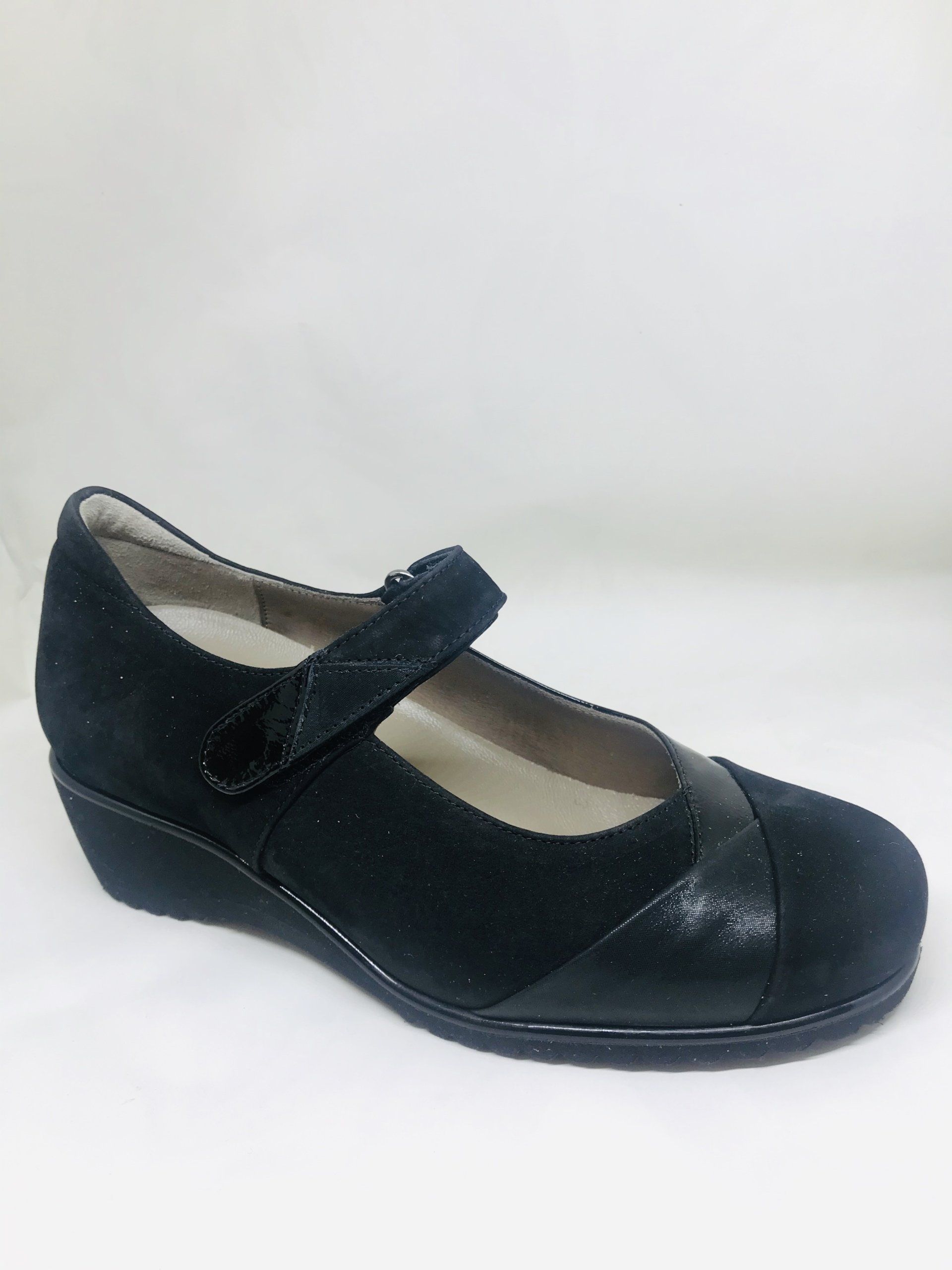 Scarpa Mary Jane nera con zeppa, cinturino e dettagli scintillanti.