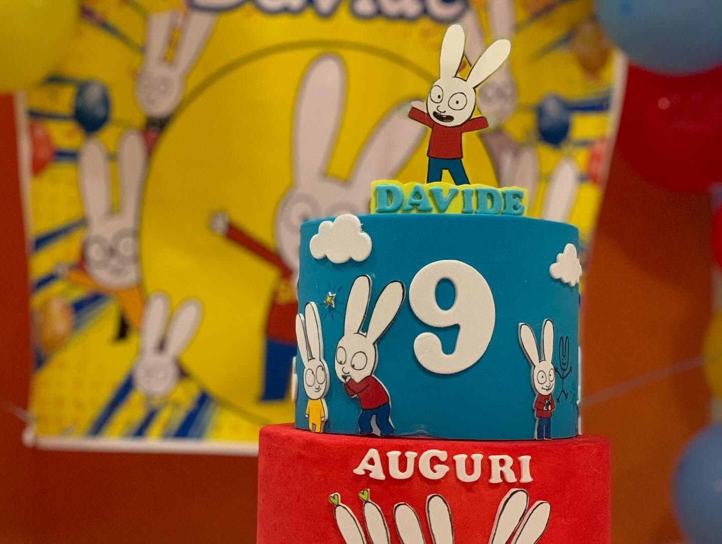 Torta di compleanno blu e rossa con decorazione a forma di coniglietto, il numero