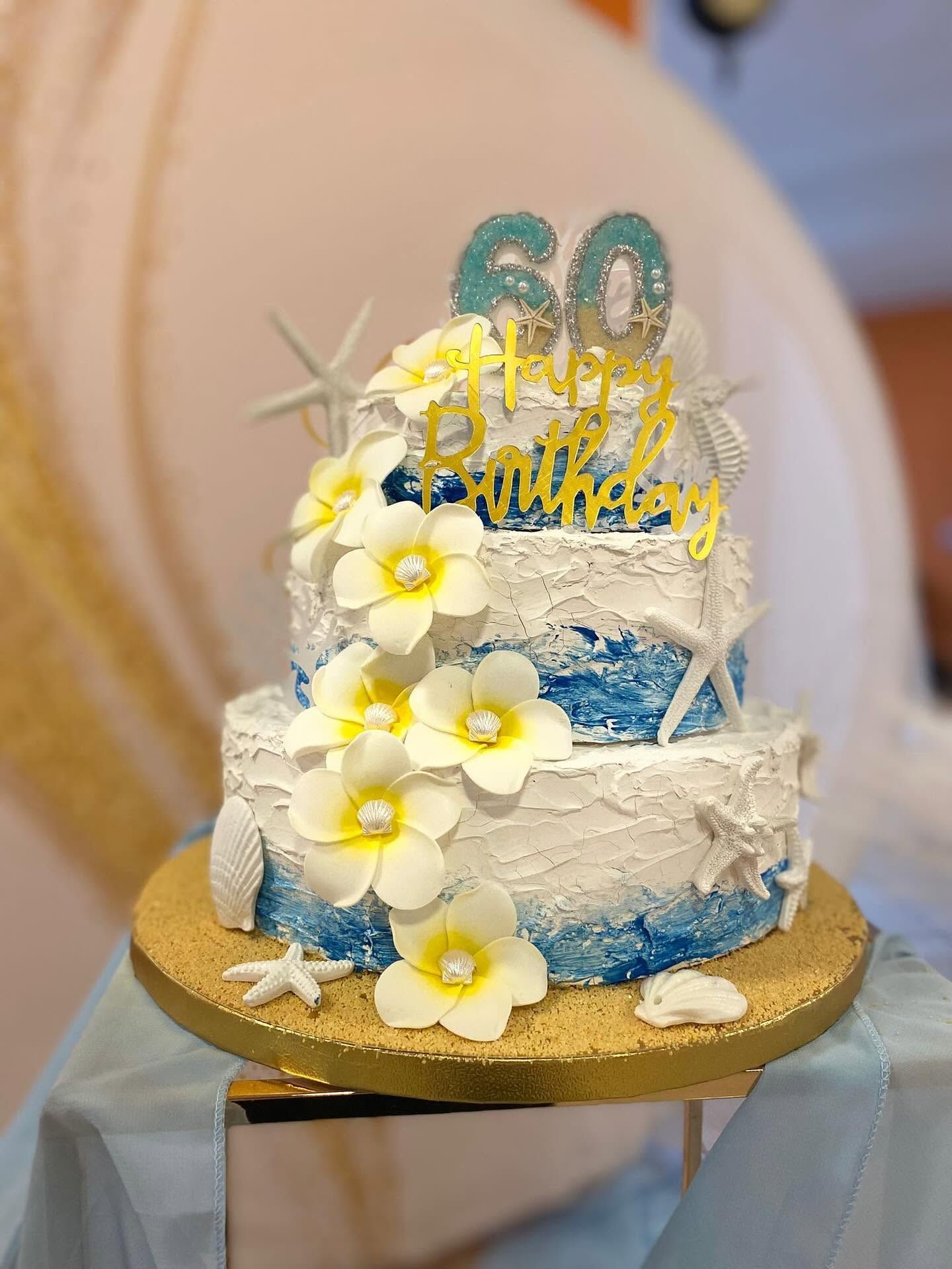 Torta di compleanno blu e bianca con fiori, decorazione dorata e il numero
