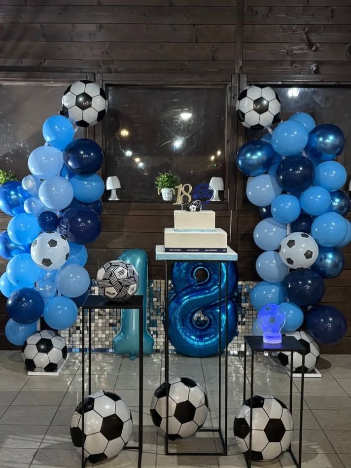 Allestimento per feste con palloncini blu e palloni da calcio, tavolo per la torta e centrotavola a specchio