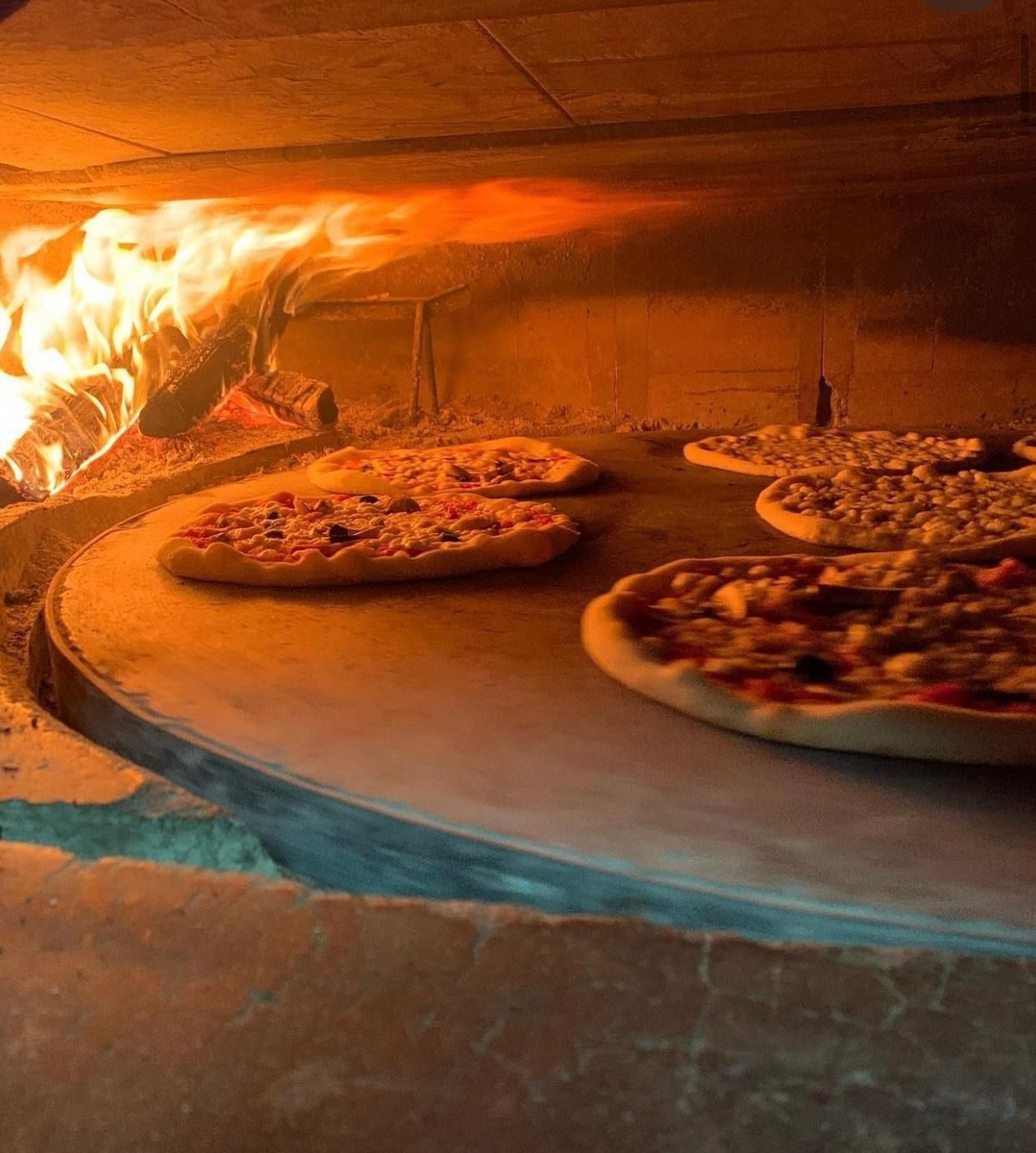Pizze che cuociono in un forno a legna