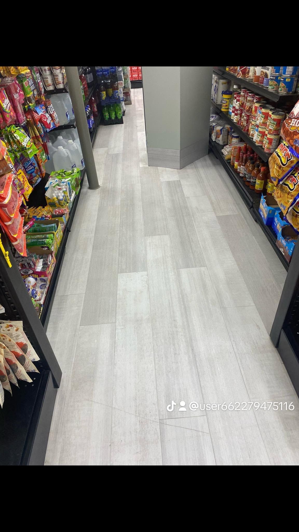 Aisle in a convenience store with snack shelves on both sides and a clear walkway.