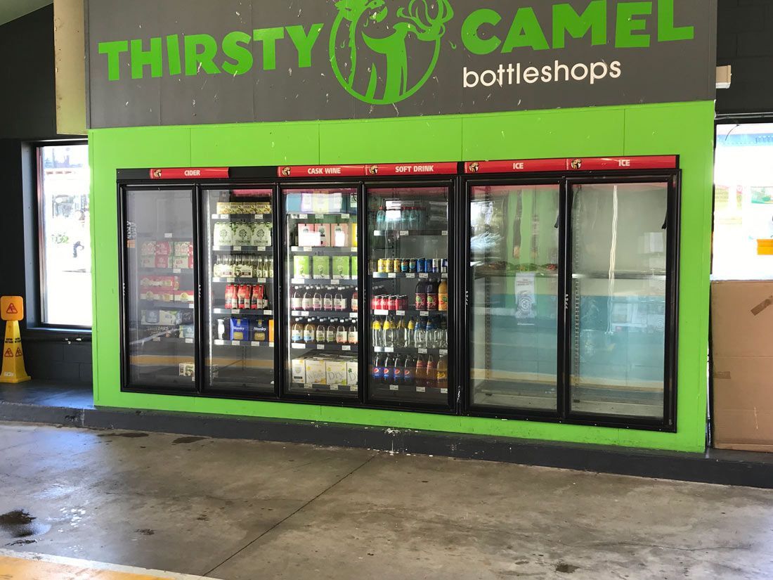 A Store Called Thirsty Camel Bottleshops With a Green Wall — Nauticool Refrigeration & Air Conditioning in Cannonvale, QLD