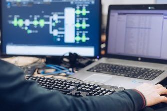 A Person is Using a Laptop Computer and a Computer Monitor — Nauticool Refrigeration & Air Conditioning in Cannonvale, QLD