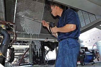 A Man is Working on a Machine With Ice Coming Out of It — Nauticool Refrigeration & Air Conditioning in Cannonvale, QLD