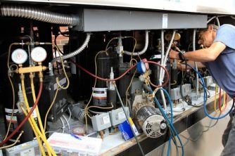 A Man is Working on the Inside of a Refrigerator — Nauticool Refrigeration & Air Conditioning in Cannonvale, QLD