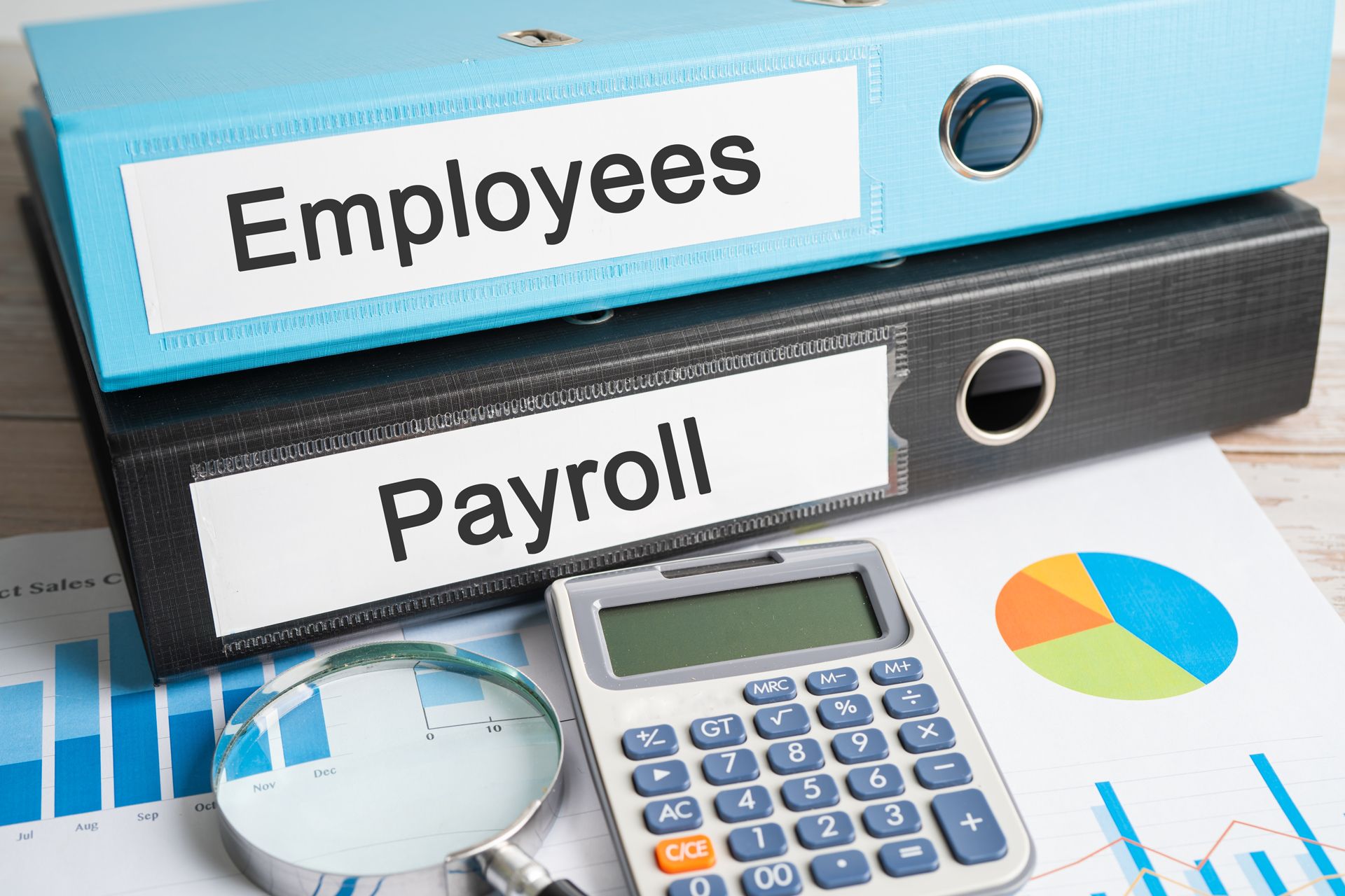 Employees and payroll binders with calculator, magnifying glass, and financial charts