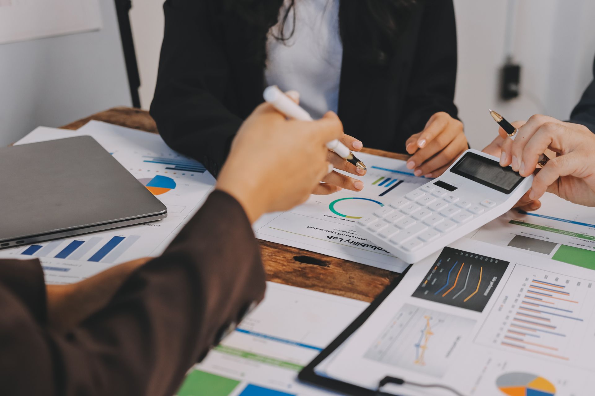 Colleagues reviewing printed charts and graphs during a business meeting at a desk