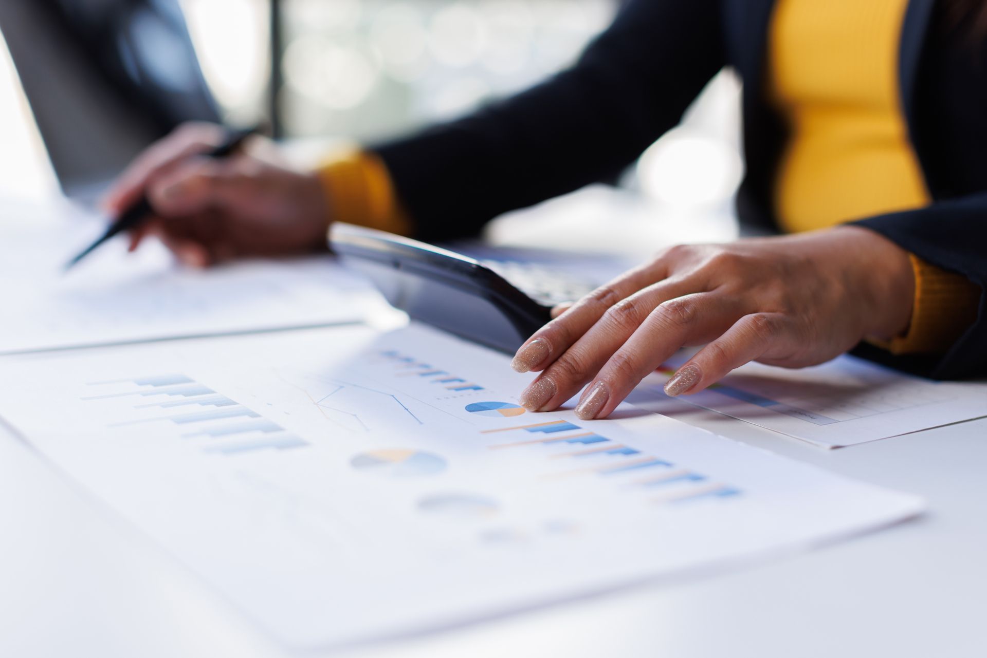 Hands reviewing charts and documents on a bright office table