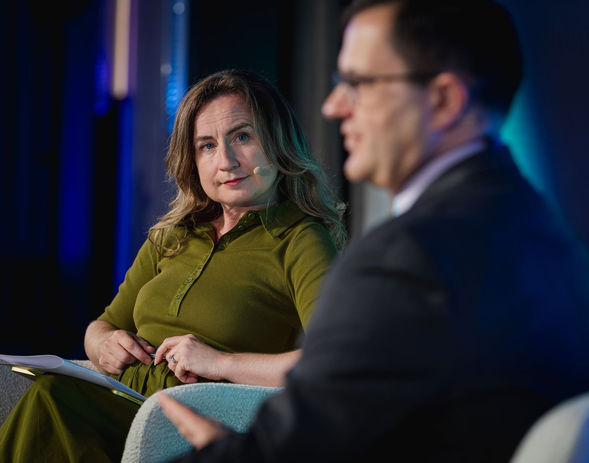 A photo taken by Ash Garwood of a woman listening at a town-hall style corporate event in London.