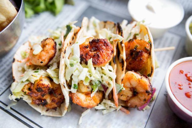 Grilled shrimp tacos with slaw, served with sauces. Grilled shrimp tacos with slaw, served with sauces.