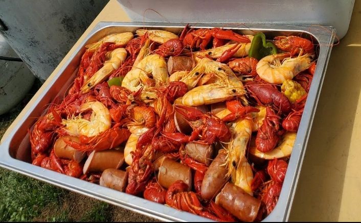 Tray of cooked crawfish, shrimp, sausage, and corn.