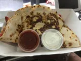 Quesadilla with tomato and sour cream dips in a white tray.