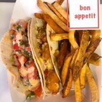 Tacos with fries in a paper container;