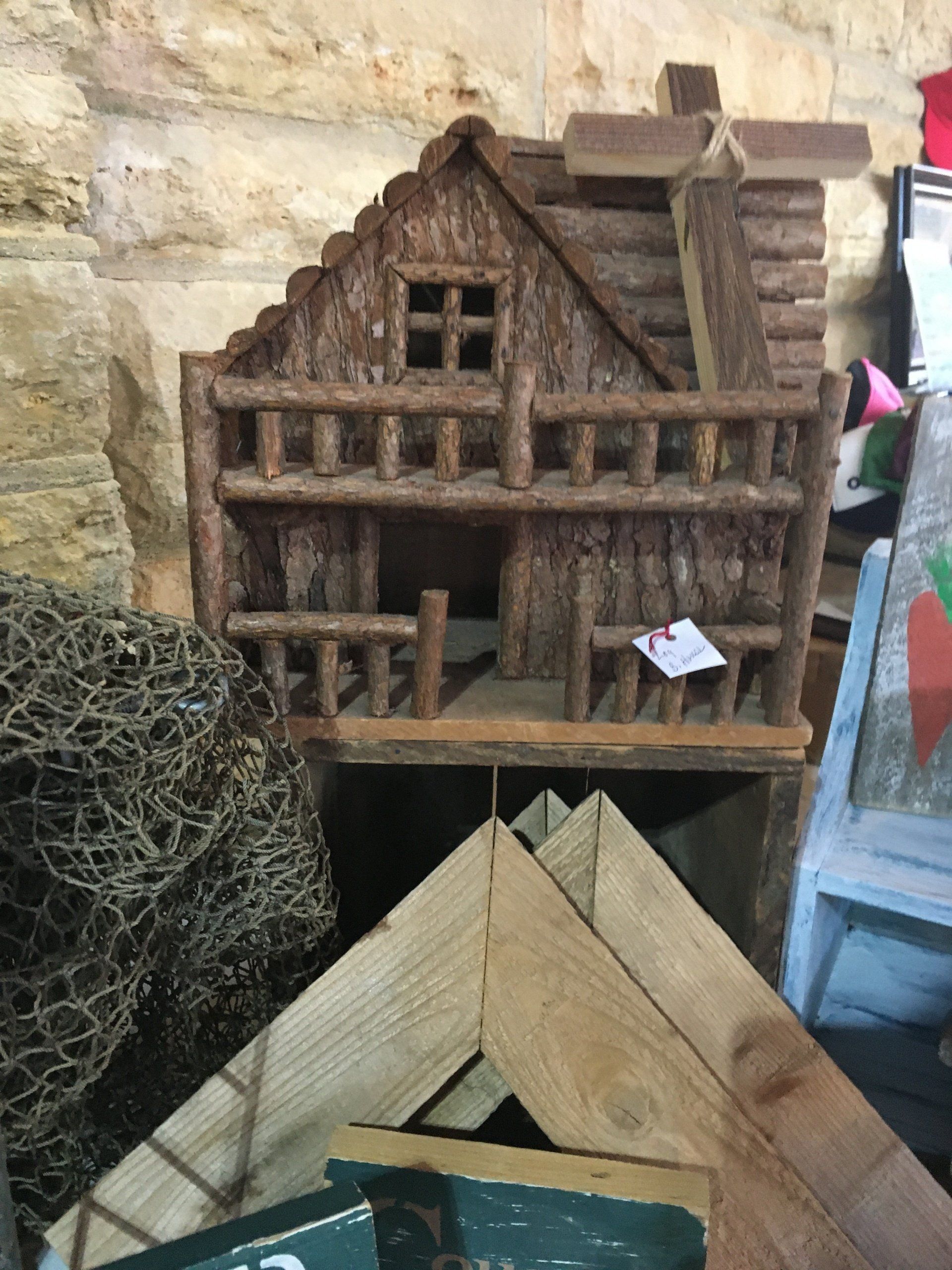 A small wooden house is sitting on top of a wooden table.