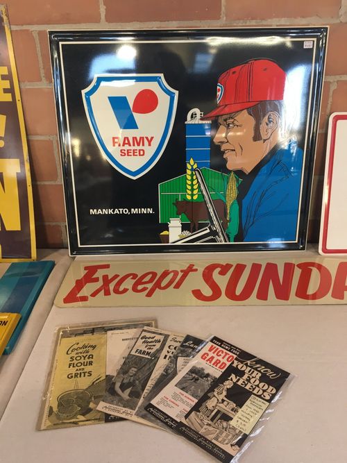 A framed picture of a man wearing a red hat and a sign that says except sunda