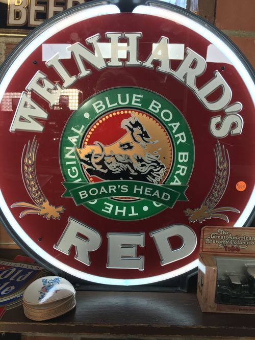 A neon sign for weinhard 's blue boar 's head red