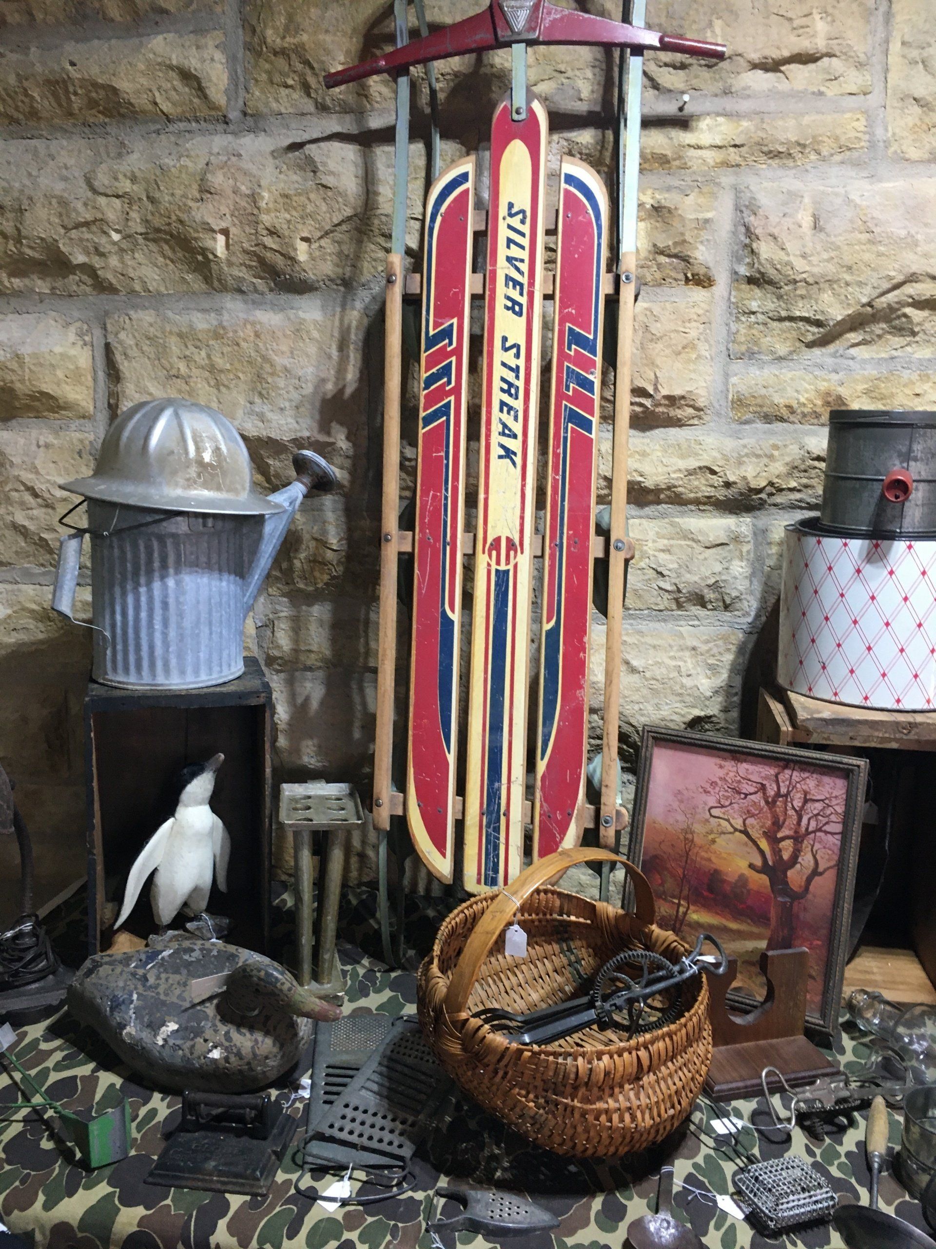 A red sled is sitting on a table next to a basket.