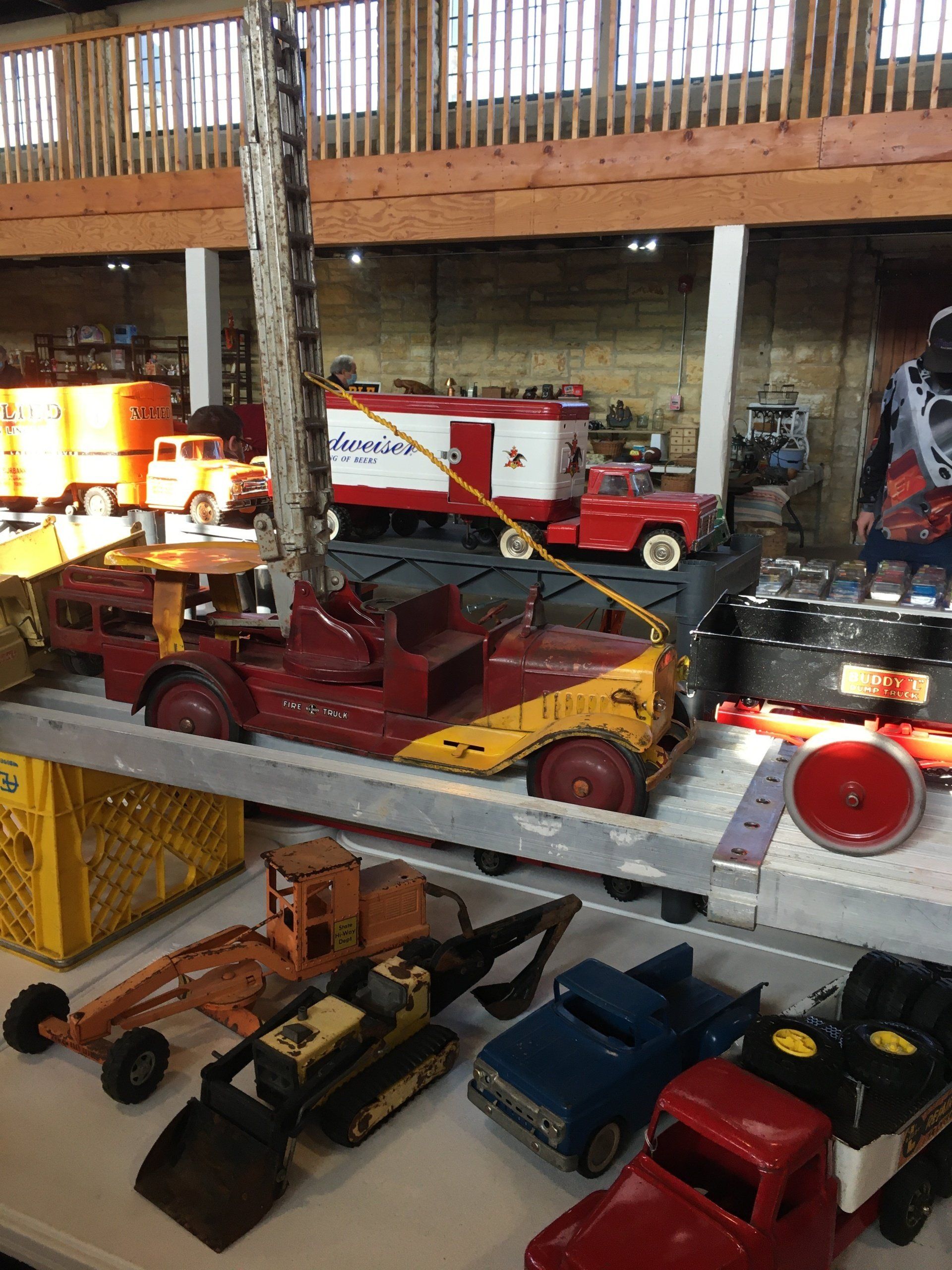 A bunch of toy trucks are on a shelf in a warehouse