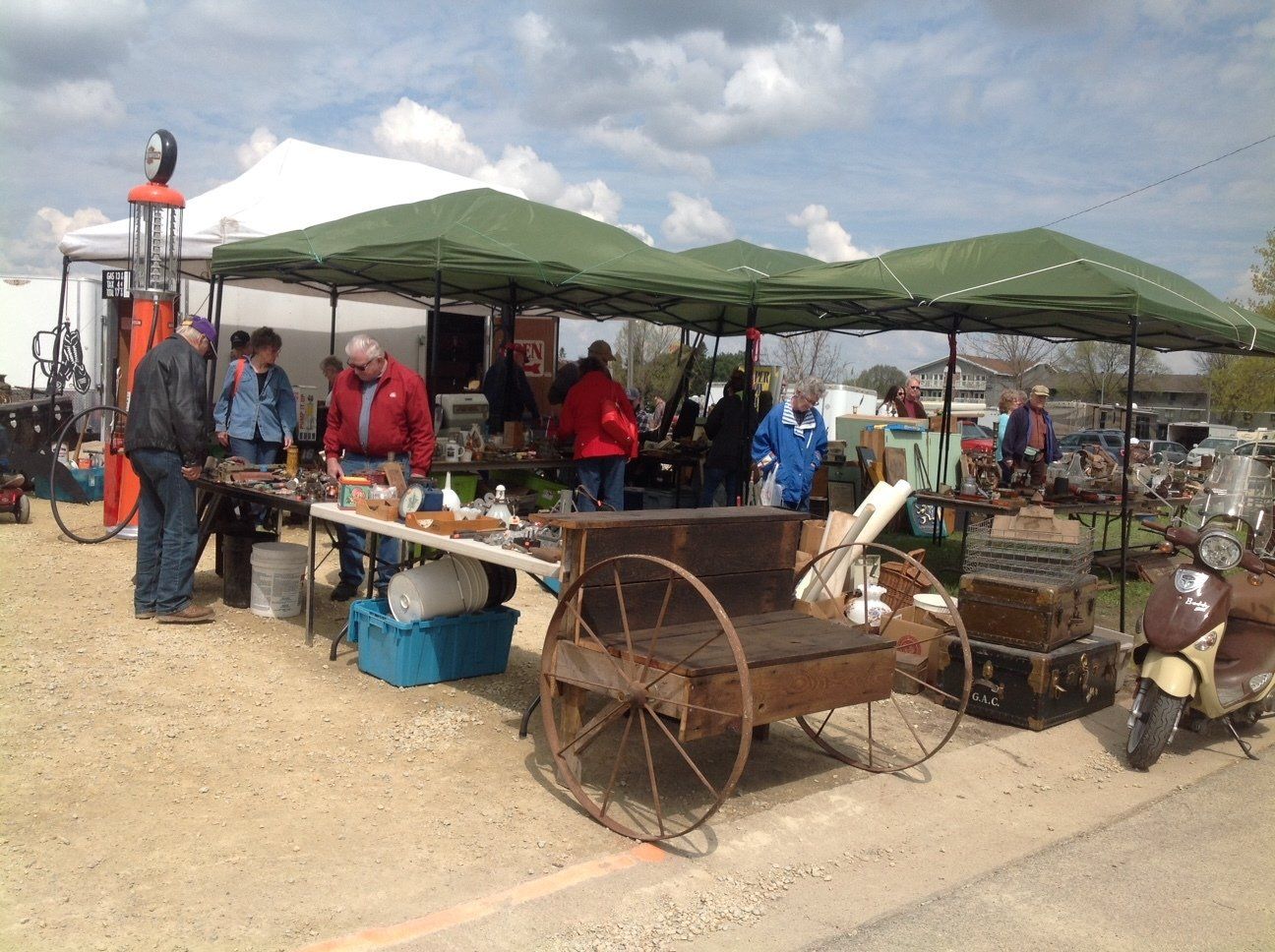 A group of people are standing around a table at a flea market.